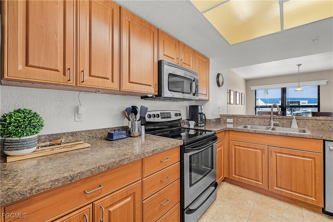 16641 Stringfellow Road, Unit 502 Bokeelia, FL 33922 - Photo 4 of 43 a kitchen with stainless steel appliances granite countertop a stove a sink and a microwave
