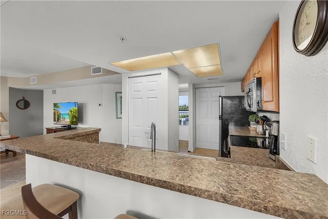 a kitchen with stainless steel appliances granite countertop a stove top oven a sink a dining table and chairs