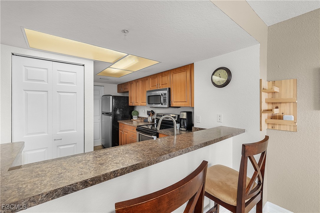 16641 Stringfellow Road, Unit 502 Bokeelia, FL 33922 - Photo 8 of 43 a dining hall with stainless steel appliances granite countertop a granite counter tops and a view of living room