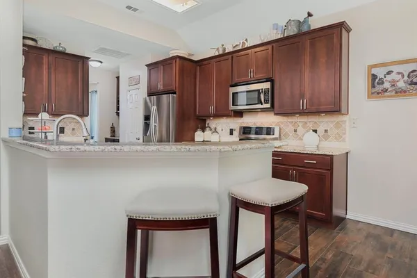 a room with kitchen island a sink cabinets and wooden floor
