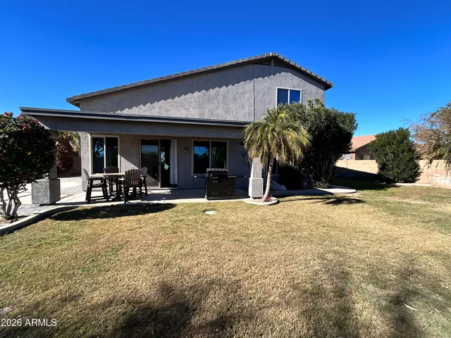 a view of a house with patio and a yard