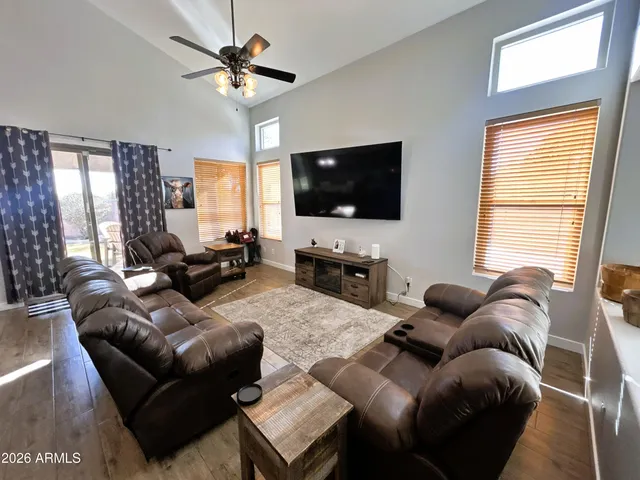 a living room with furniture a flat screen tv and a large window