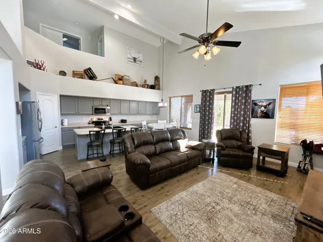 a living room with furniture kitchen view and a window
