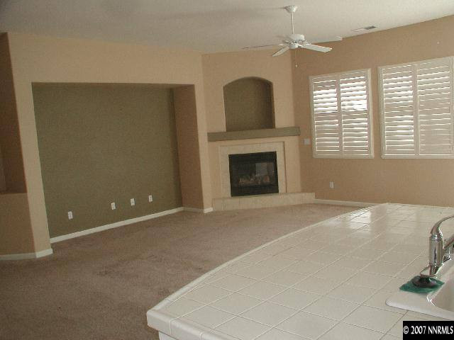 10431 Blockade Drive Reno, NV 89521 - Photo 5 of 7 a view of an empty room with a fireplace and a window