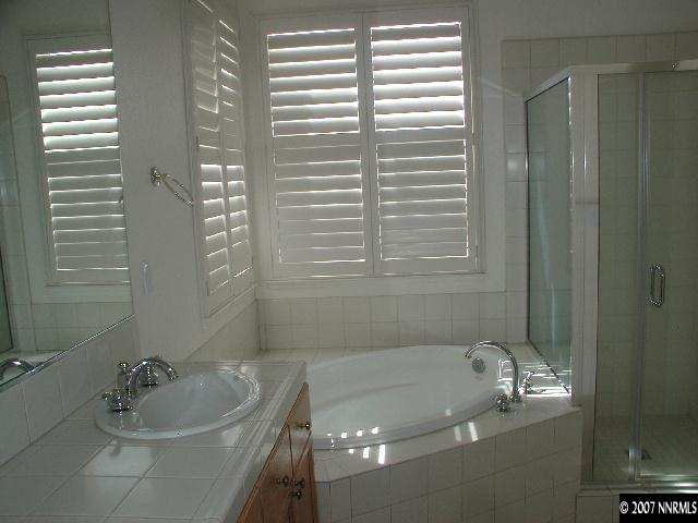 10431 Blockade Drive Reno, NV 89521 - Photo 6 of 7 a bathroom with a tub a sink and a window
