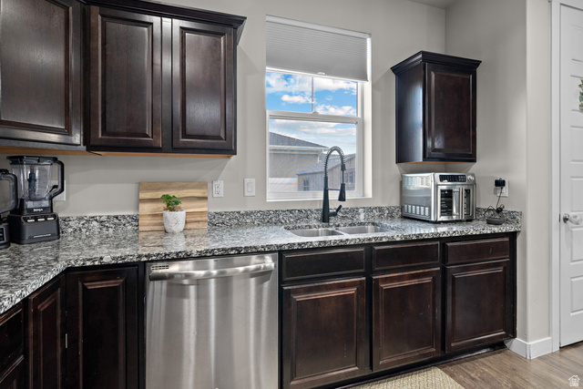 1074 South 750 West Springville, UT 84663 - Photo 10 of 28 Kitchen featuring dark wood cabinetry, speckled countertops, a stainless steel dishwasher, an undermount dual-basin sink with a matte black gooseneck faucet, and a window with a cellular shade
