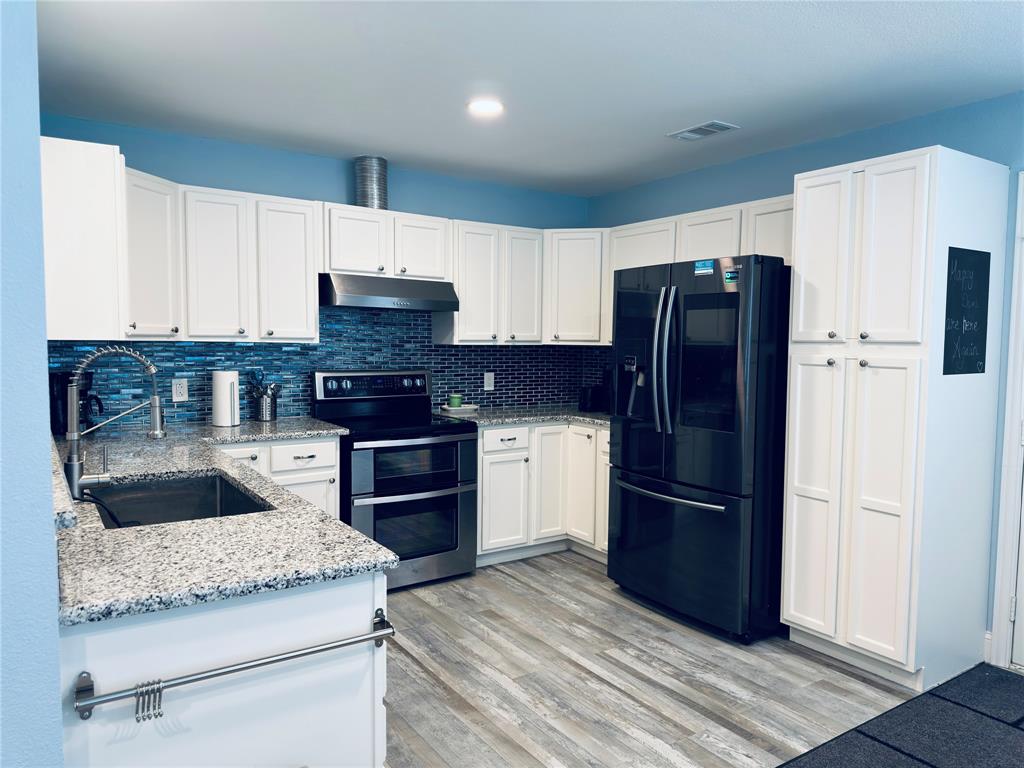 619 Rs County Road 3350 Emory, TX 75440 - Photo 10 of 40 a kitchen with granite countertop wooden cabinets and a stainless steel appliances