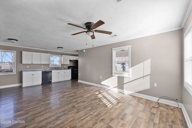 a view of a kitchen with wooden floor and a ceiling fan