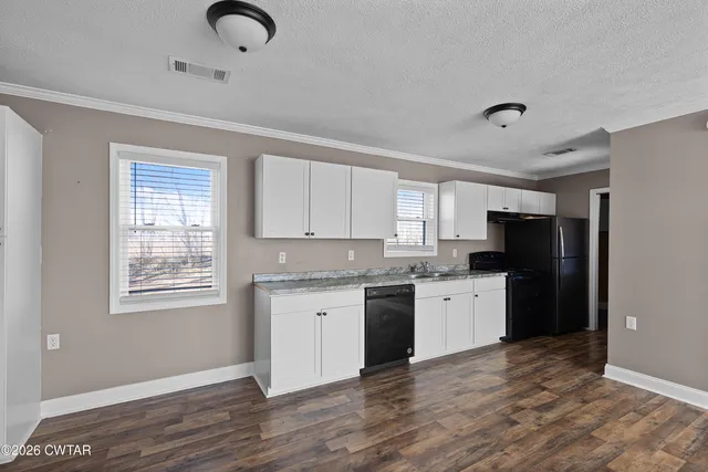 a view of kitchen with granite countertop cabinets and window