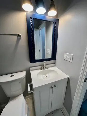 a bathroom with a toilet sink and mirror