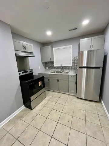 a kitchen with stainless steel appliances a refrigerator sink and cabinets