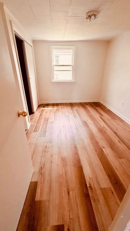 245 County Street, Unit 10 Fall River, MA 02723 - Photo 5 of 9 an empty room with wooden floor and windows