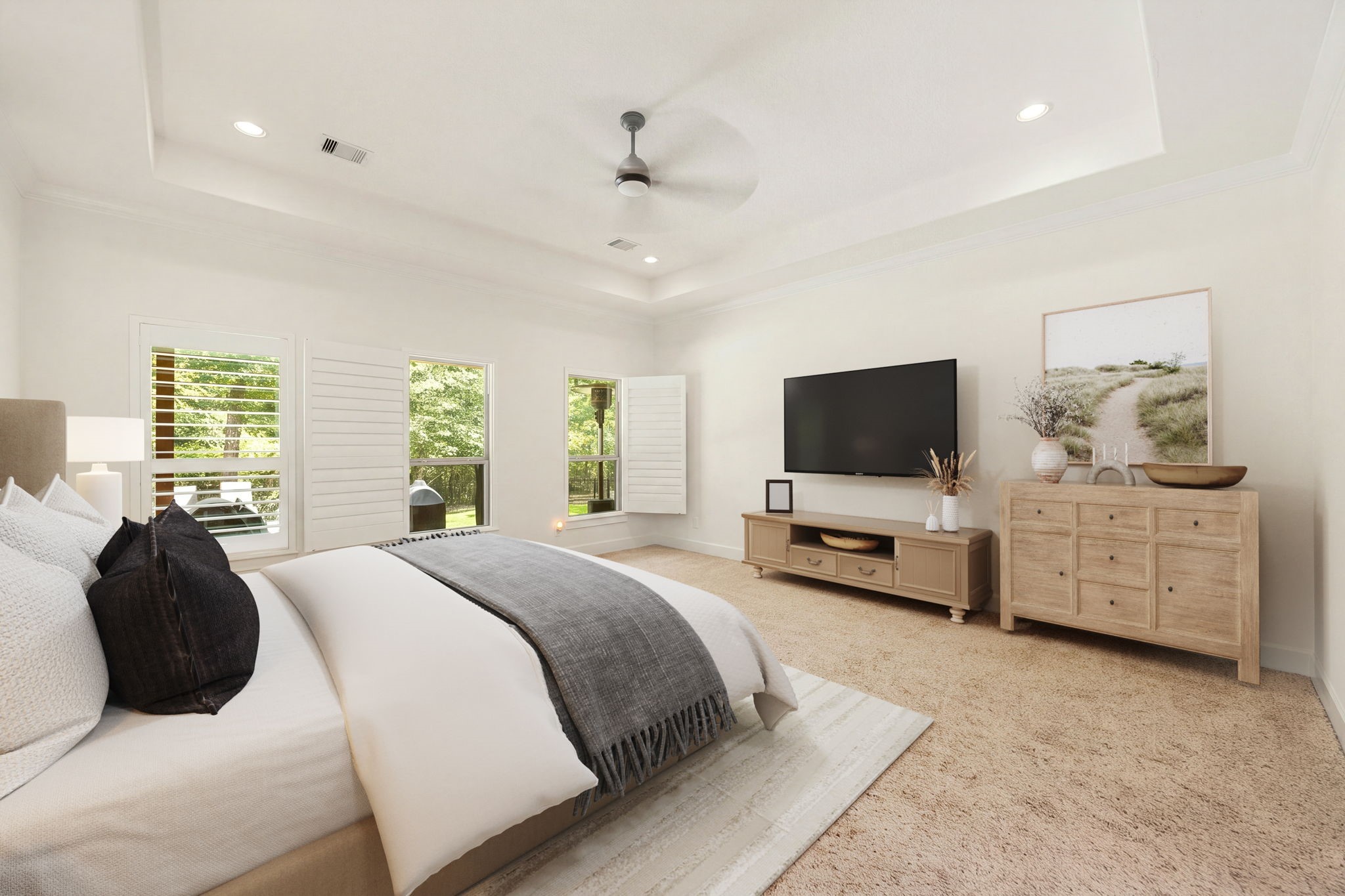 1904 Boulder Ridge Drive Conroe, TX 77304 - Photo 22 of 37 The spacious primary bedroom serves as a serene retreat, highlighted by an elegant deep tray ceiling and recessed lighting. Three large windows outfitted with plantation shutters fill the room with beautiful natural light while offering peaceful views of the surrounding greenery. *Virtually Staged.