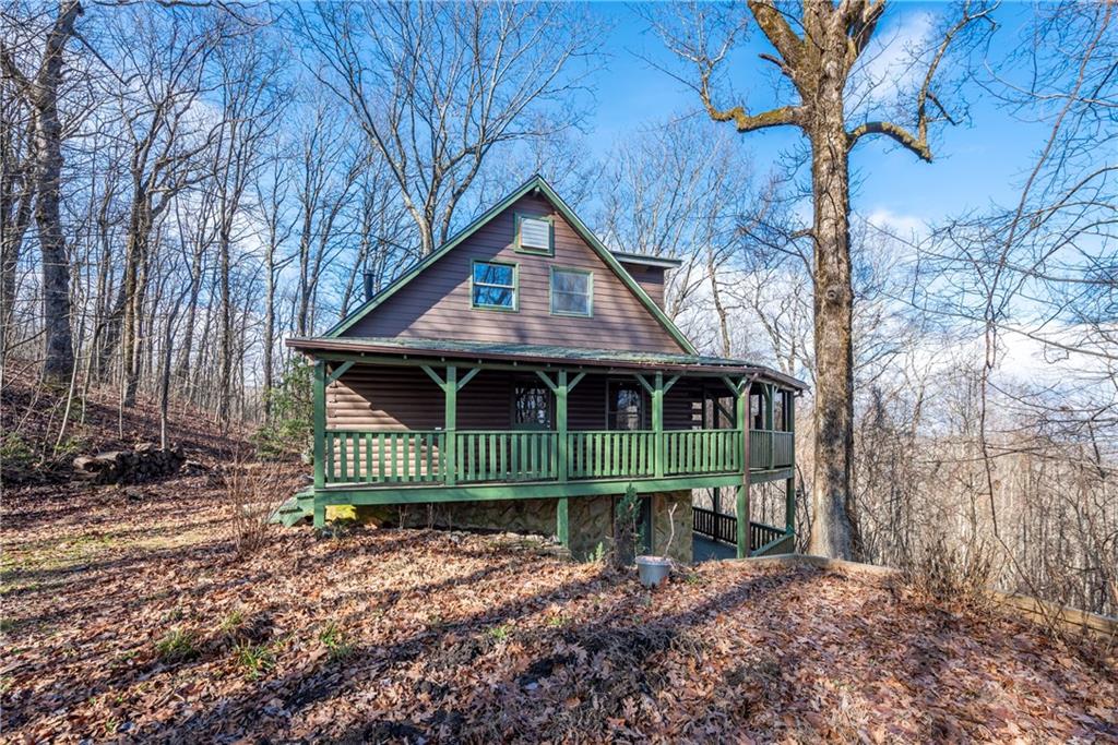 a front view of a house with a garden and trees