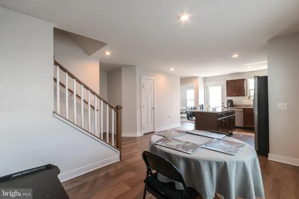 a living room with stainless steel appliances kitchen island granite countertop furniture and a wooden floor