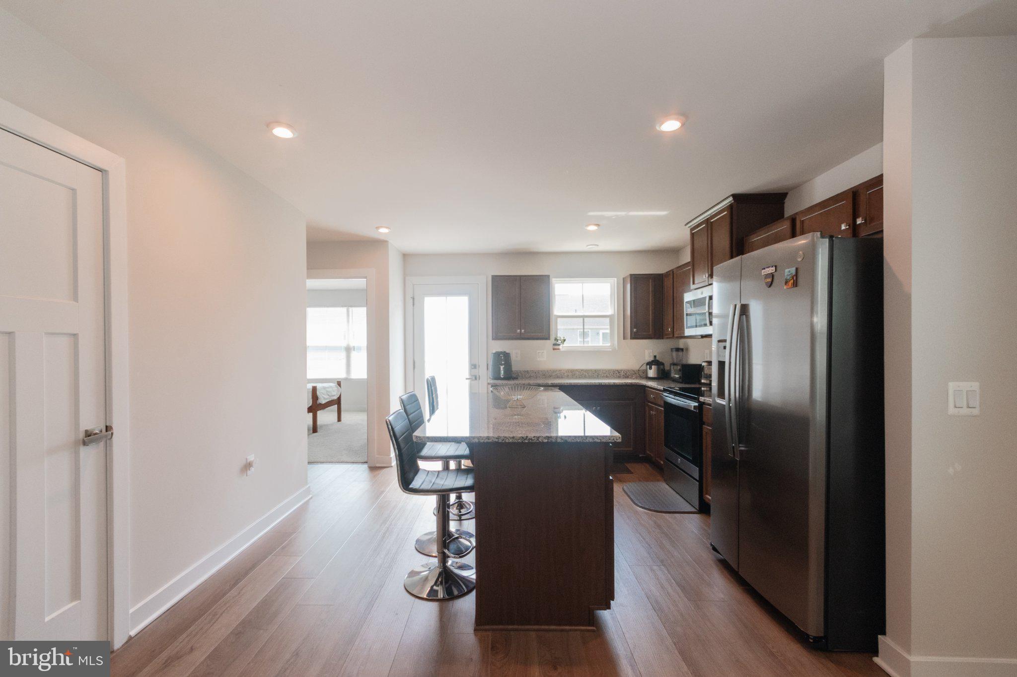 109 Blantons Road Martinsburg, WV 25405 - Photo 19 of 55 a kitchen with refrigerator a sink dishwasher a dining table and chairs with wooden floor