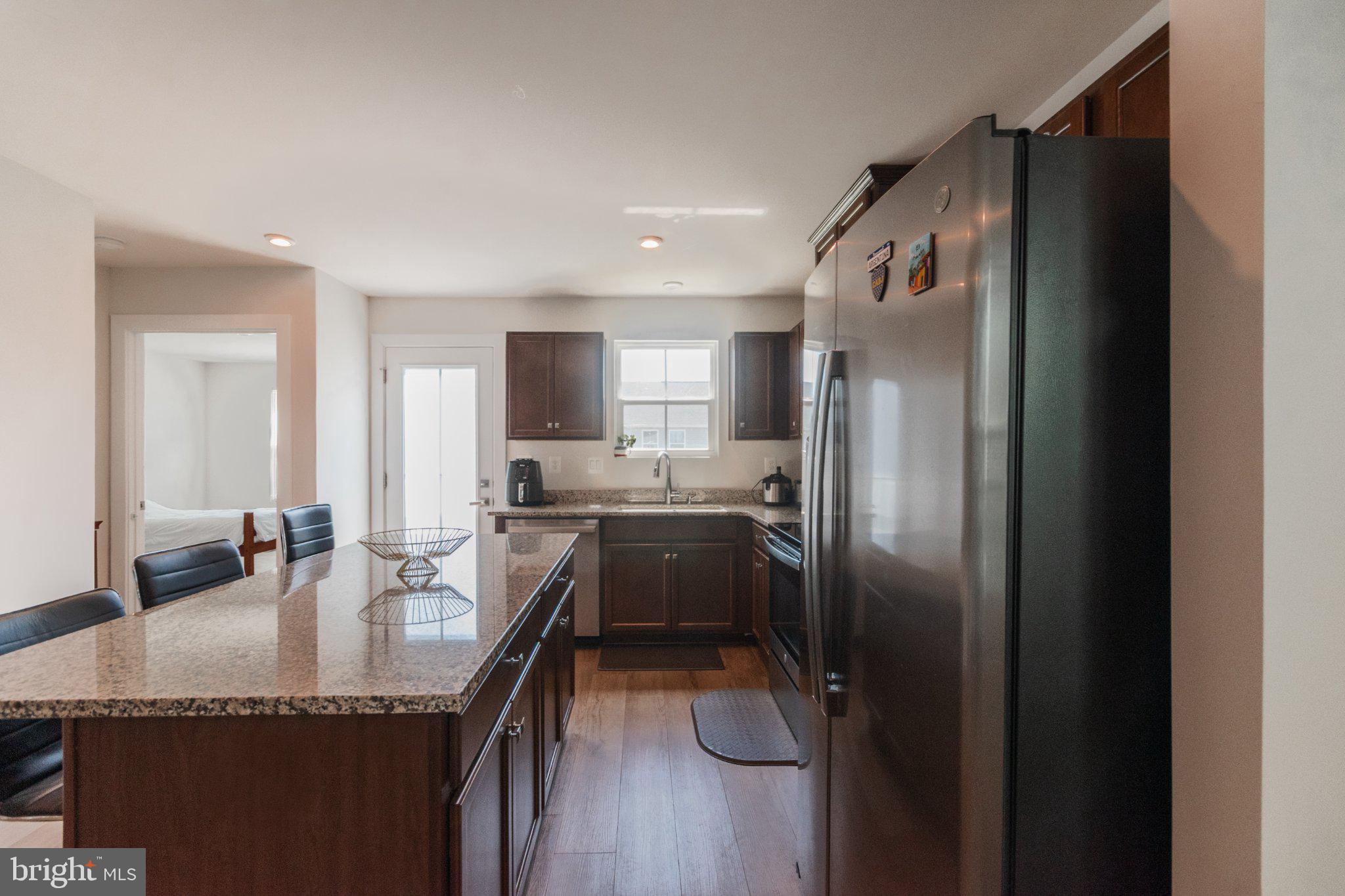 109 Blantons Road Martinsburg, WV 25405 - Photo 22 of 55 a kitchen with granite countertop a refrigerator a sink a stove and chairs
