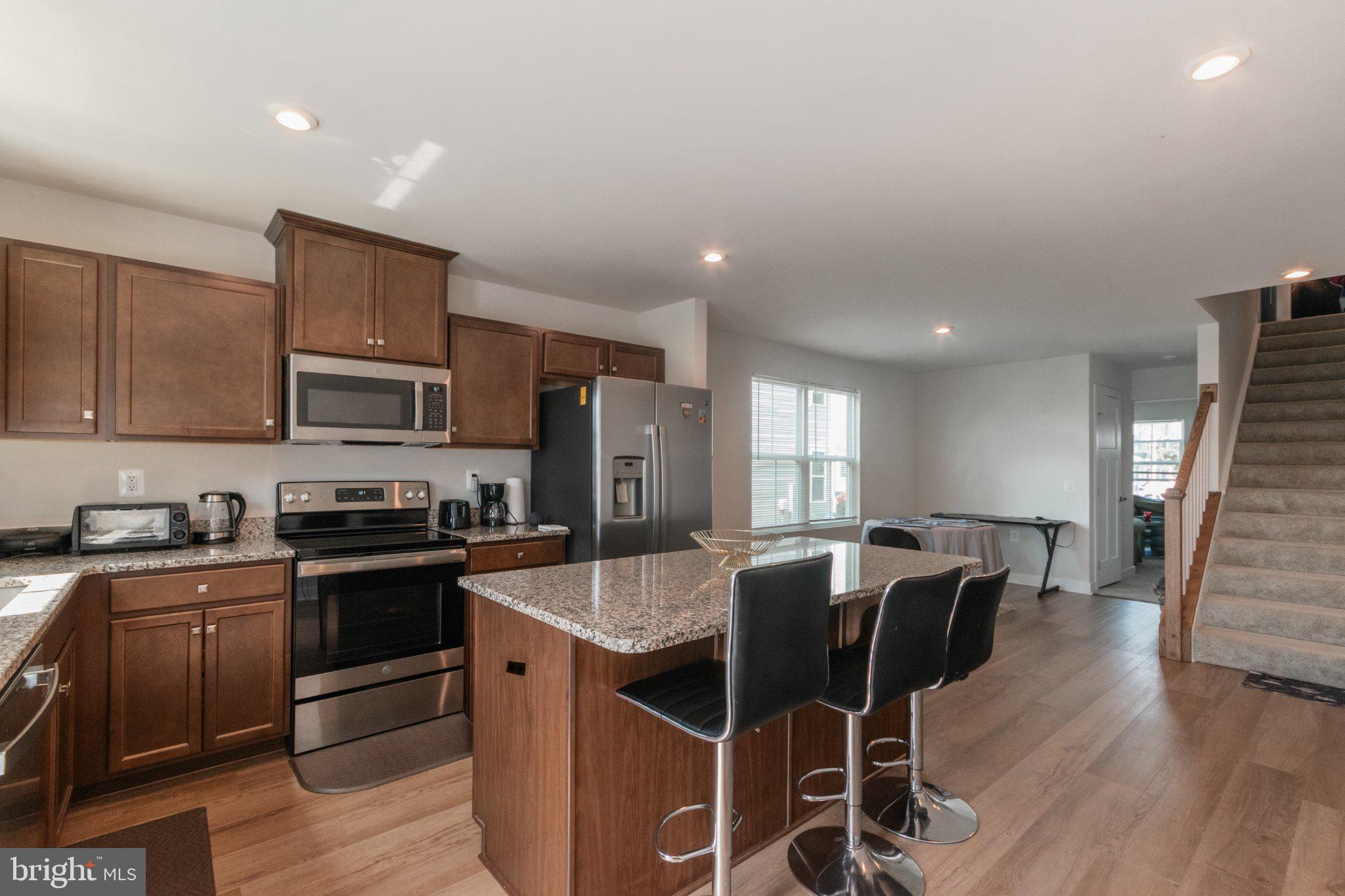 109 Blantons Road Martinsburg, WV 25405 - Photo 24 of 55 a kitchen with stainless steel appliances granite countertop wooden floors a stove a microwave a sink and a refrigerator