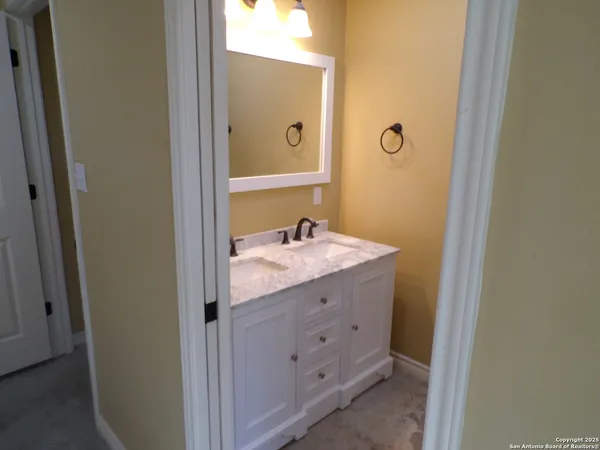 a bathroom with a granite countertop sink and a mirror
