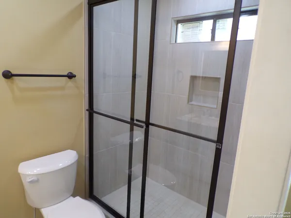 a white toilet sitting next to a shower