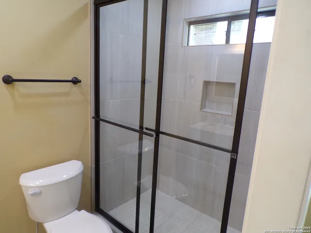 a white toilet sitting next to a shower