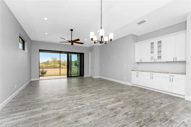 an empty room with a window and a ceiling fan