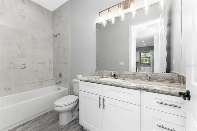 an empty room with ceiling fan and window