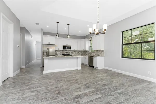 a kitchen with kitchen island granite countertop appliances cabinets and a sink