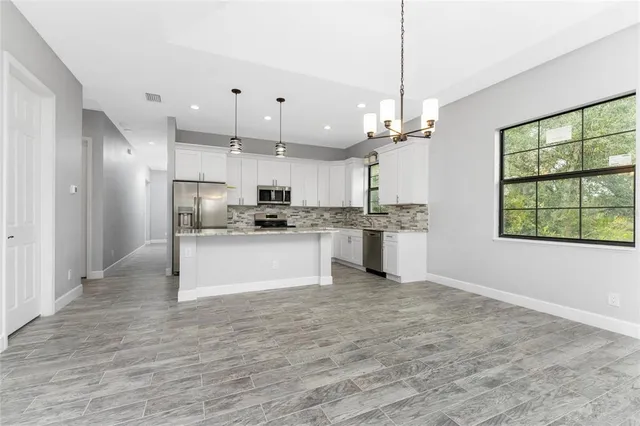 a kitchen with kitchen island granite countertop appliances cabinets and a sink