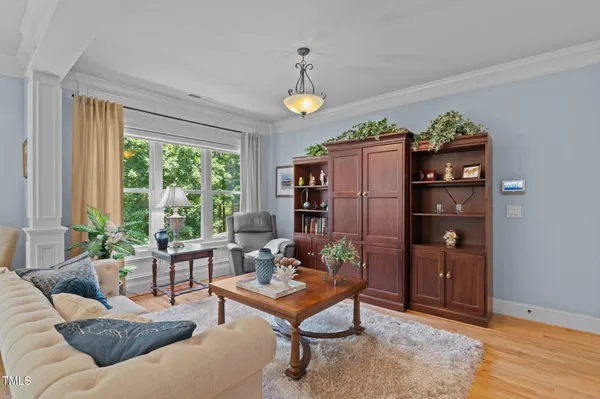 a view of a patio with table and chairs potted plants and floor to ceiling window