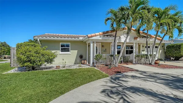 a front view of a house with a yard and potted plants