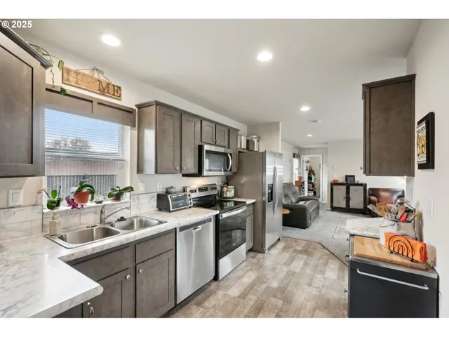 a kitchen that has a lot of cabinets a sink and appliances