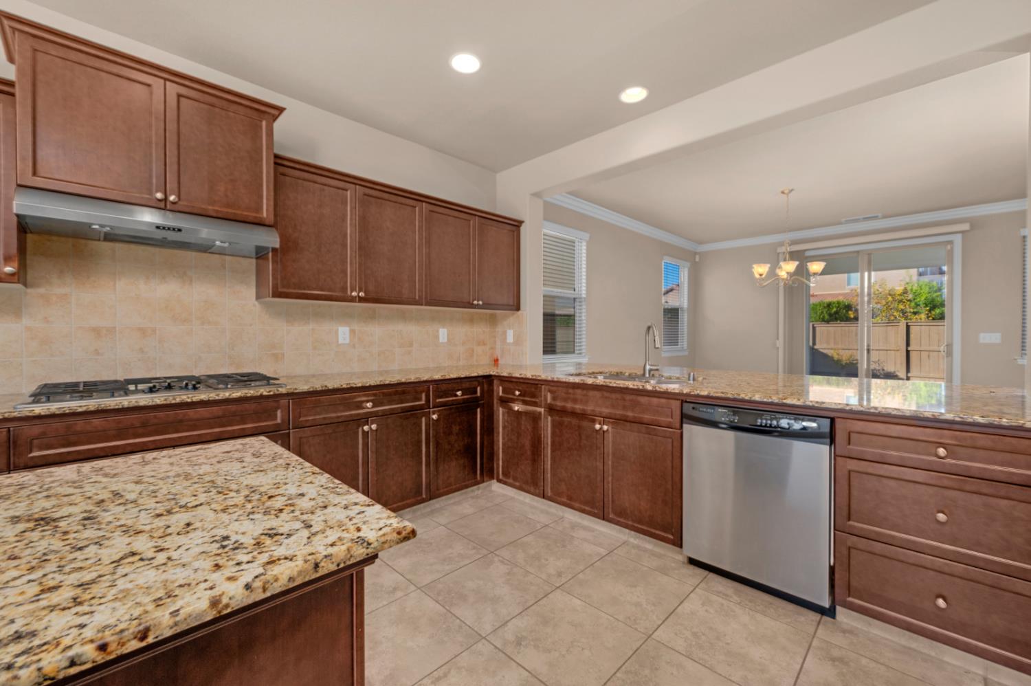 3267 Portals Avenue Clovis, CA 93619 - Photo 33 of 69 a kitchen with granite countertop wooden cabinets and a stove top oven