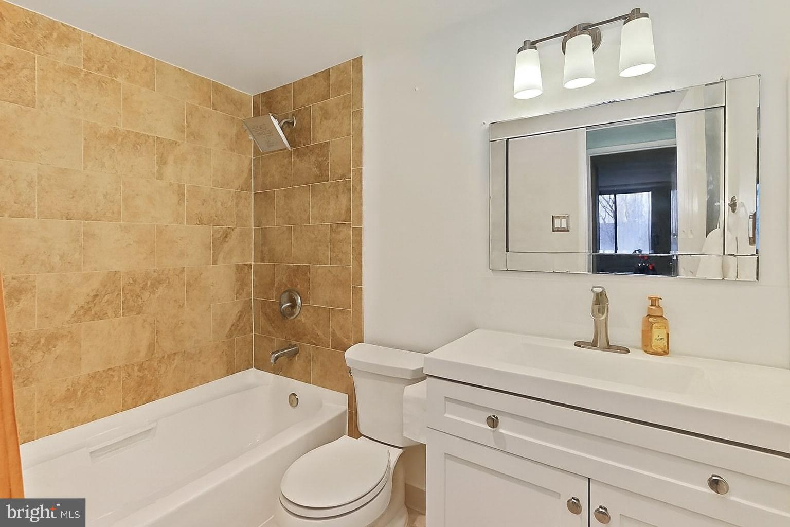 6301 Stevenson Avenue, Unit 914 Alexandria, VA 22304 - Photo 7 of 9 a bathroom with a toilet a sink a mirror and bathtub