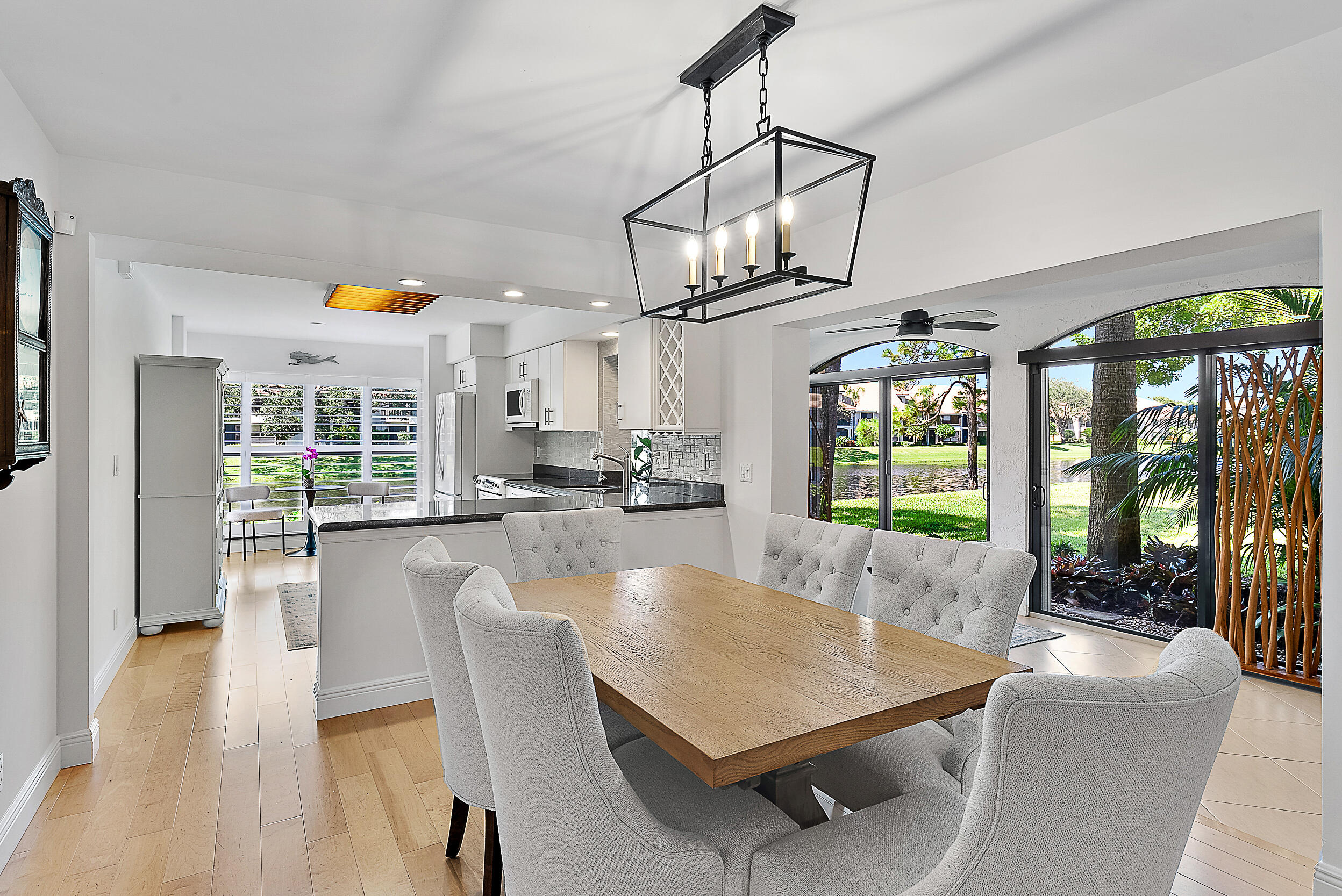 16647 Traders Crossing North, Unit 126 Jupiter, FL 33477 - Photo 2 of 45 a dining room with stainless steel appliances granite countertop a couch and a dining table with chairs