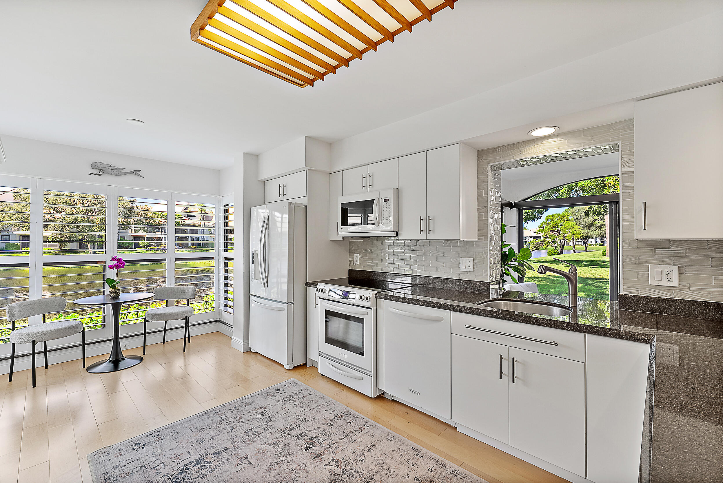 16647 Traders Crossing North, Unit 126 Jupiter, FL 33477 - Photo 6 of 45 a kitchen with a stove a sink and a refrigerator