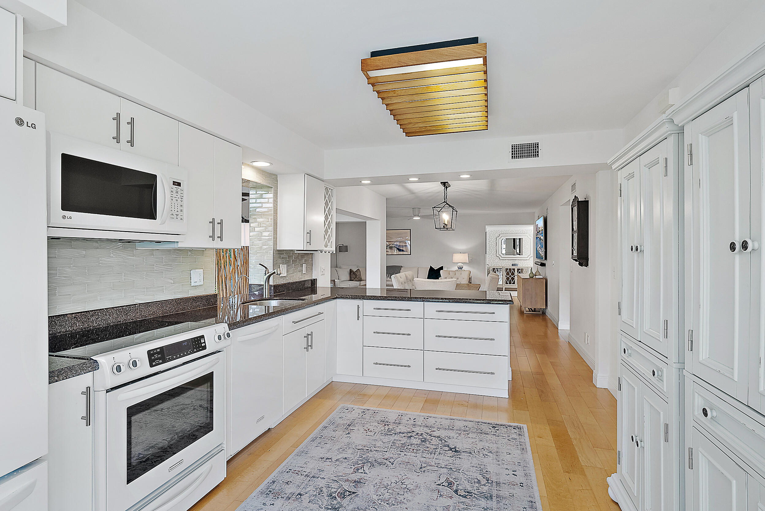 16647 Traders Crossing North, Unit 126 Jupiter, FL 33477 - Photo 8 of 45 a kitchen with granite countertop a sink stainless steel appliances and cabinets