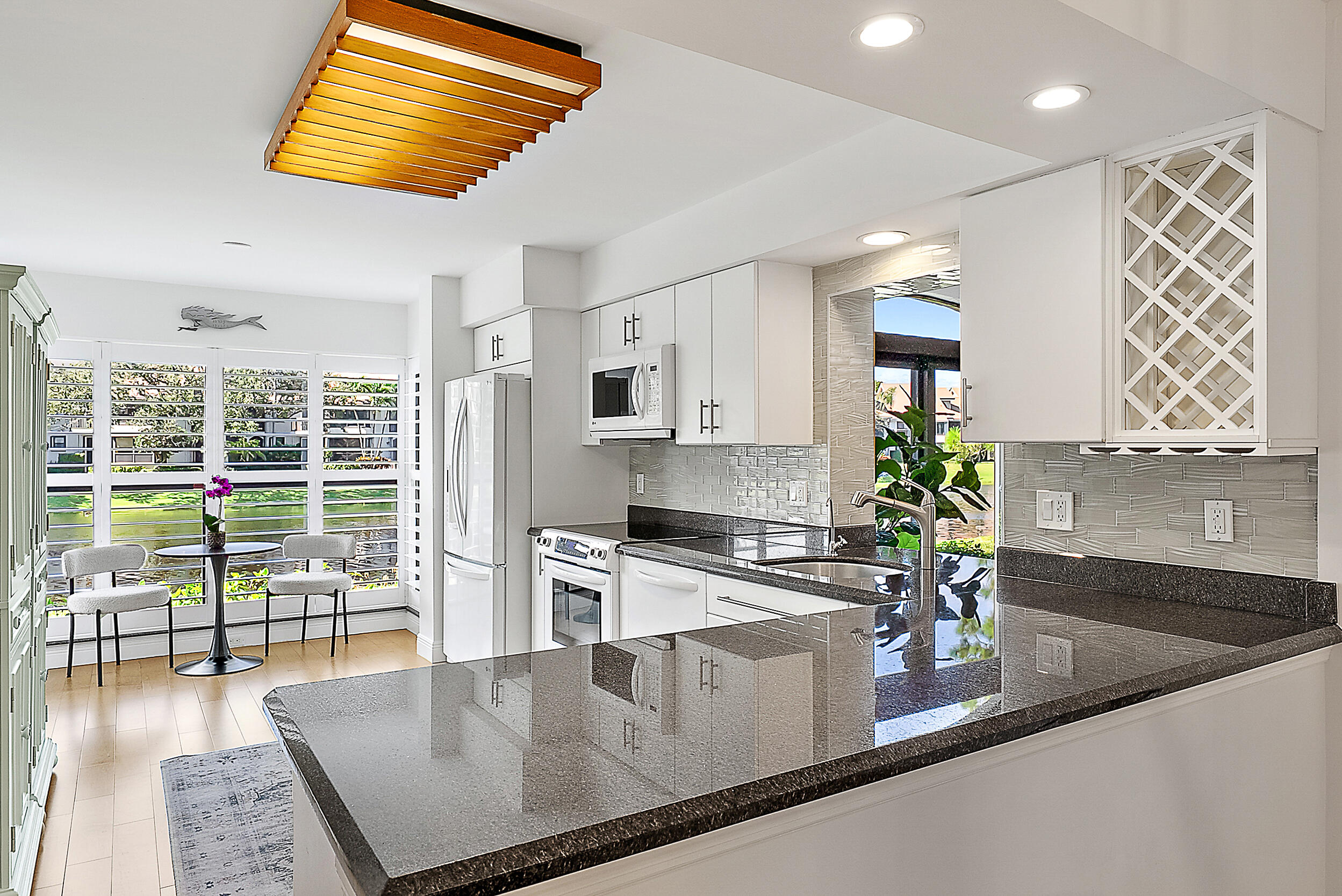 16647 Traders Crossing North, Unit 126 Jupiter, FL 33477 - Photo 9 of 45 a kitchen with stainless steel appliances granite countertop a sink a stove and a wooden floors