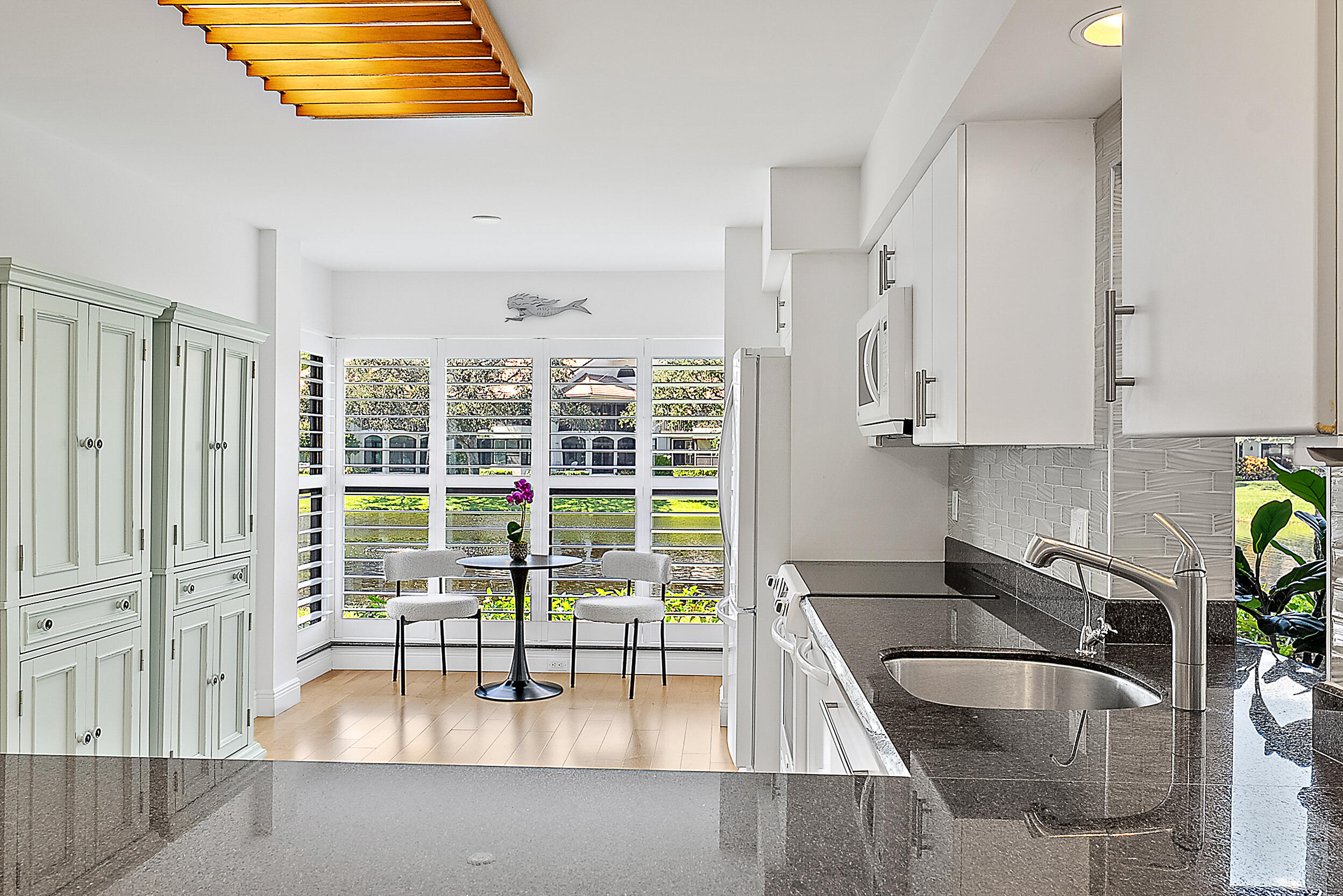 16647 Traders Crossing North, Unit 126 Jupiter, FL 33477 - Photo 10 of 45 a kitchen with granite countertop a sink a stove and cabinets