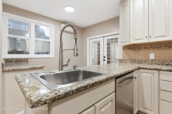 a kitchen with granite countertop a sink and cabinets
