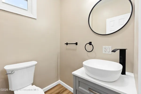 a bathroom with a toilet a sink and mirror