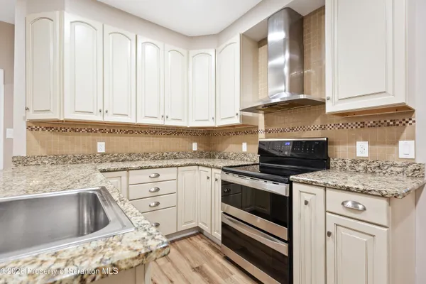 a kitchen with granite countertop white cabinets and white appliances