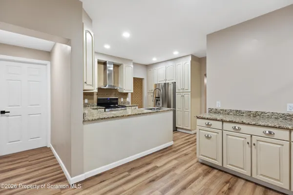 a kitchen with stainless steel appliances granite countertop a refrigerator and a stove top oven