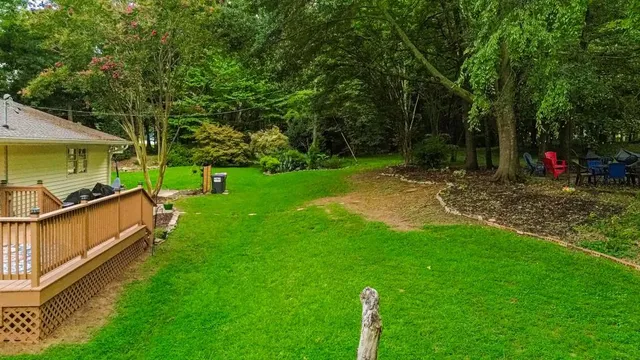 a view of a backyard with a barn and large trees