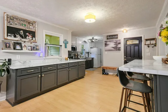 a kitchen with a table chairs refrigerator and window