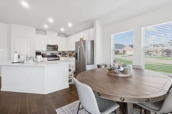 a kitchen with refrigerator cabinets dining table and chairs