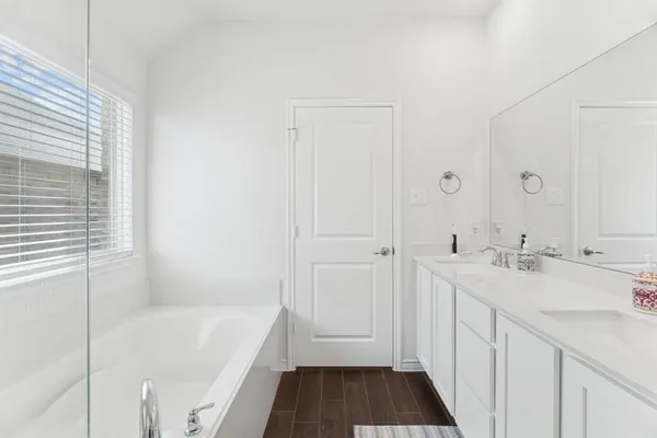 a bathroom with a tub sink and mirror