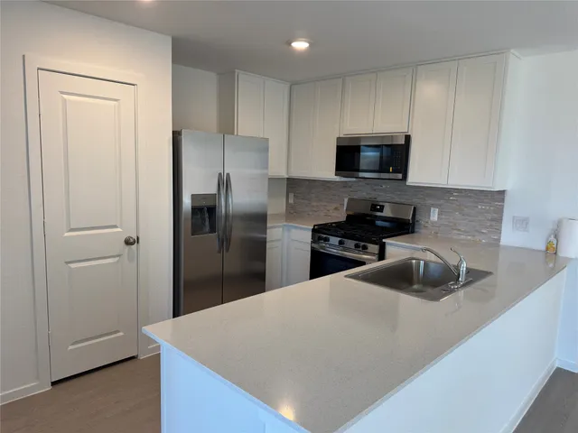 a kitchen with cabinets and stainless steel appliances