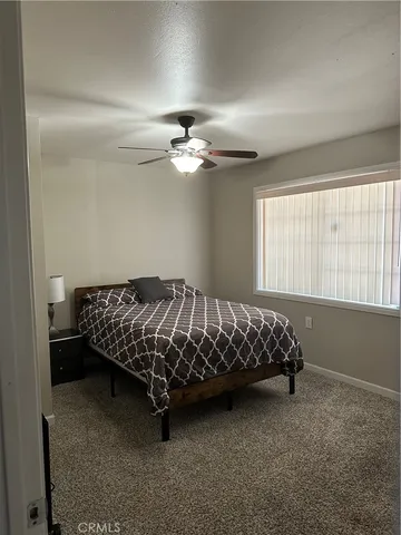 a bed sitting in a bedroom next to a window