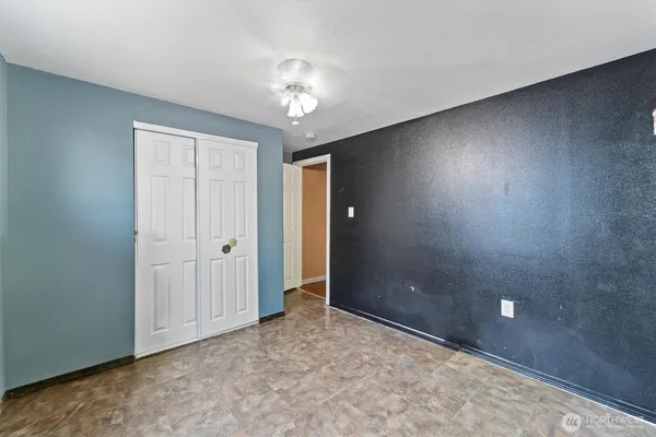 a view of an empty room with a chandelier fan